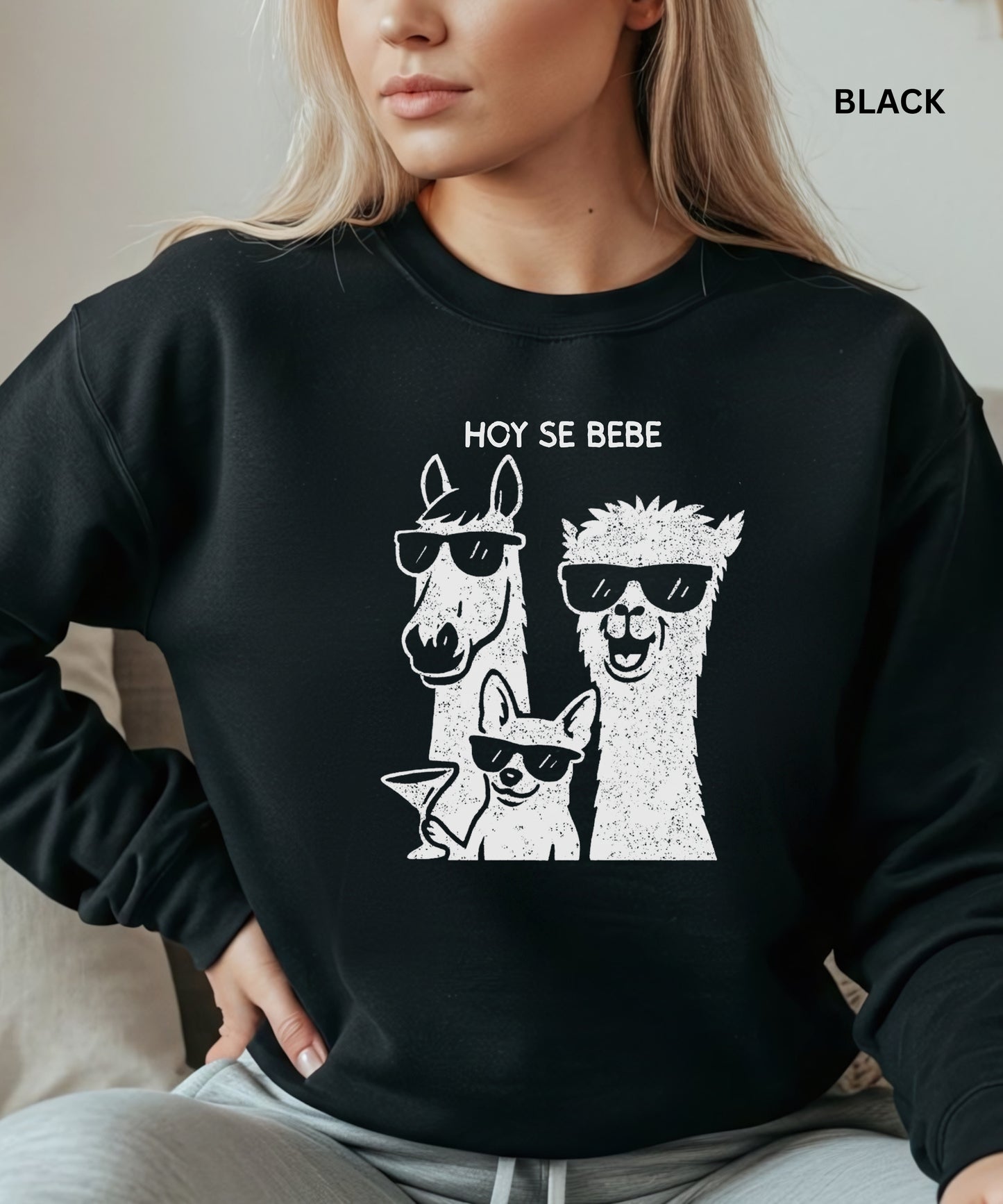 Person wearing a black sweatshirt with llama and dog graphic and 'HOY SE BEBE' text.