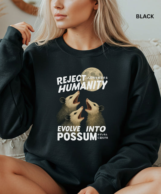Person wearing a black colored sweatshirt with a graphic design that says "reject humanity evolve into possum" sitting on a couch.