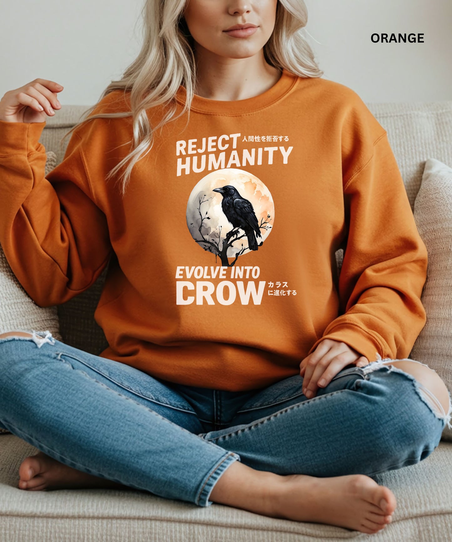 Person wearing an orange sweatshirt with a graphic design that says "reject humanity evolve into crow" sitting on a couch.