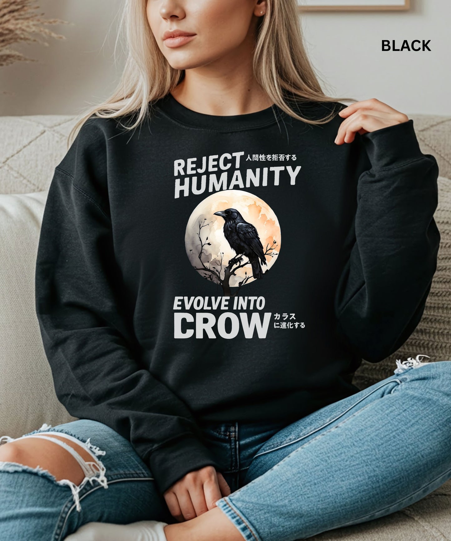 Person wearing a black sweatshirt with a graphic design that says "reject humanity evolve into crow" sitting on a couch.