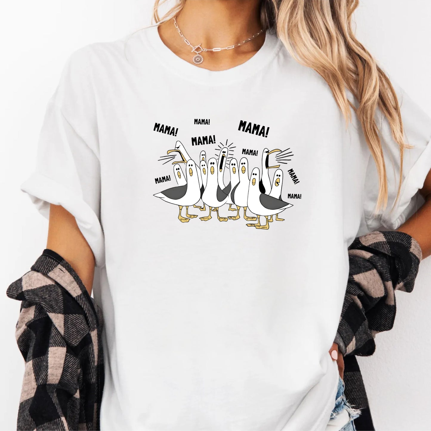 White t-shirt with cartoon penguins screaming "Mama"  design and text worn by a person.