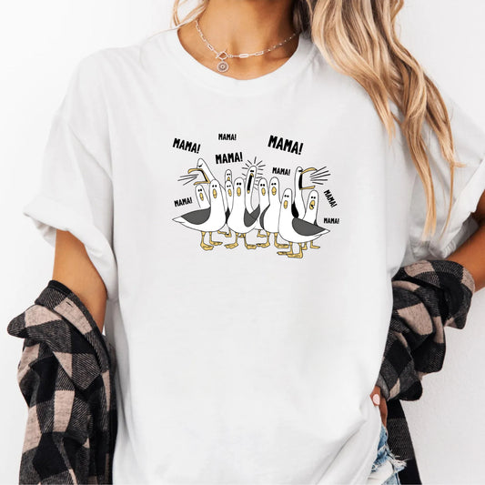 White t-shirt with cartoon penguins screaming "Mama"  design and text worn by a person.