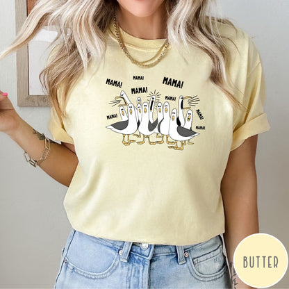 butter t-shirt with cartoon penguins screaming "Mama"  design and text worn by a person.