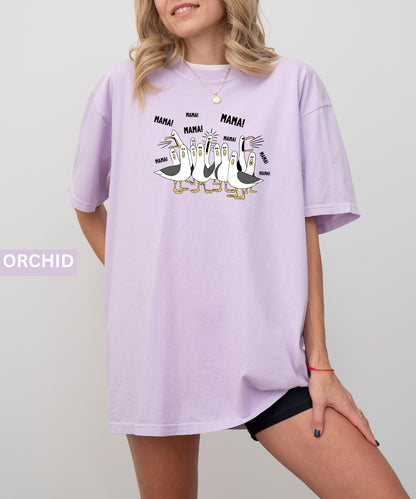 orchid t-shirt with cartoon penguins screaming "Mama"  design and text worn by a person.