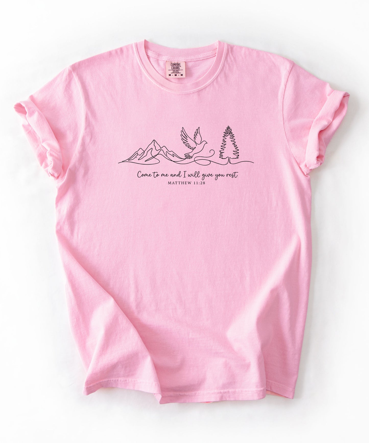  a light pink t-shirt with nature-themed design and text that says "come to me and i will give you rest matthew 11:28" 