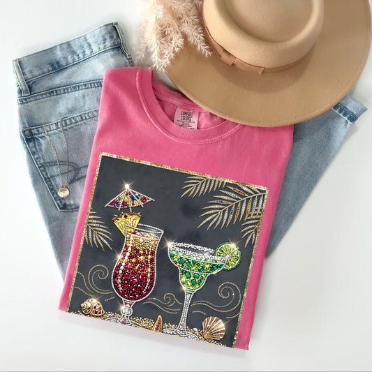 Pink t-shirt with cocktail design, denim jeans, and a hat on a white background