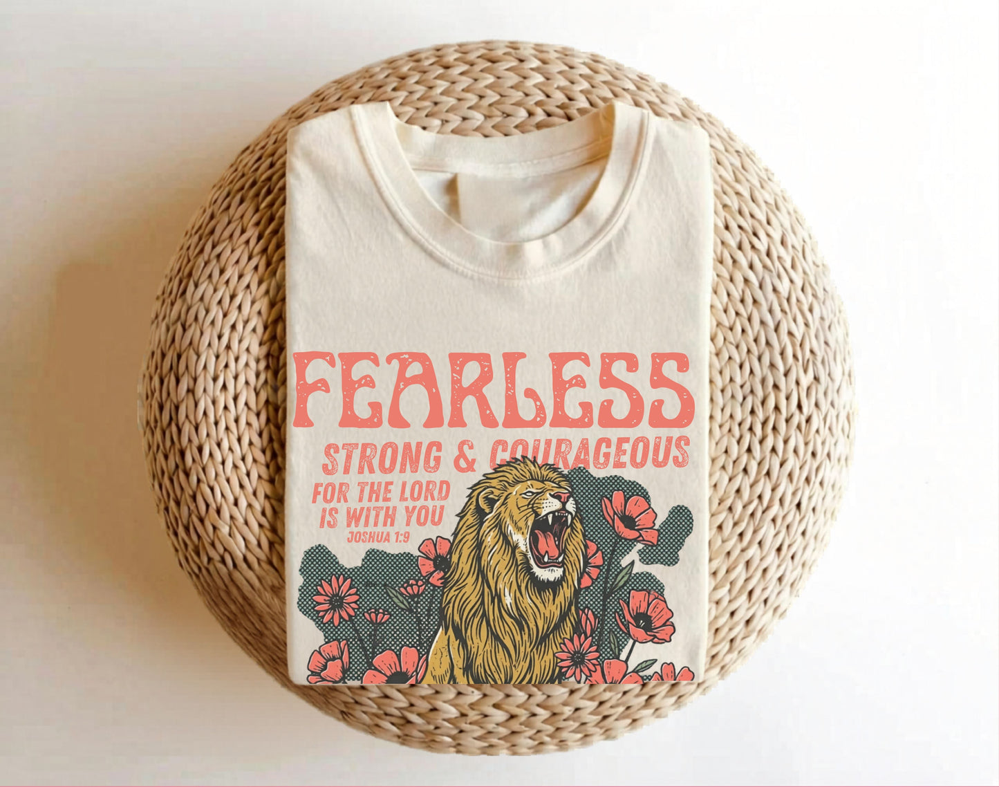 ivory shirt with 'Fearless Strong & Courageous' text and lion design on a woven surface.