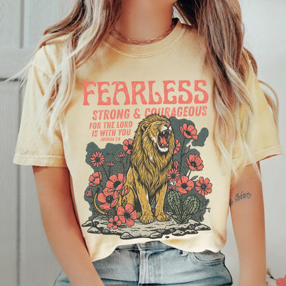 Person wearing butter colored t-shirt with a lion graphic and motivational text against a plain background