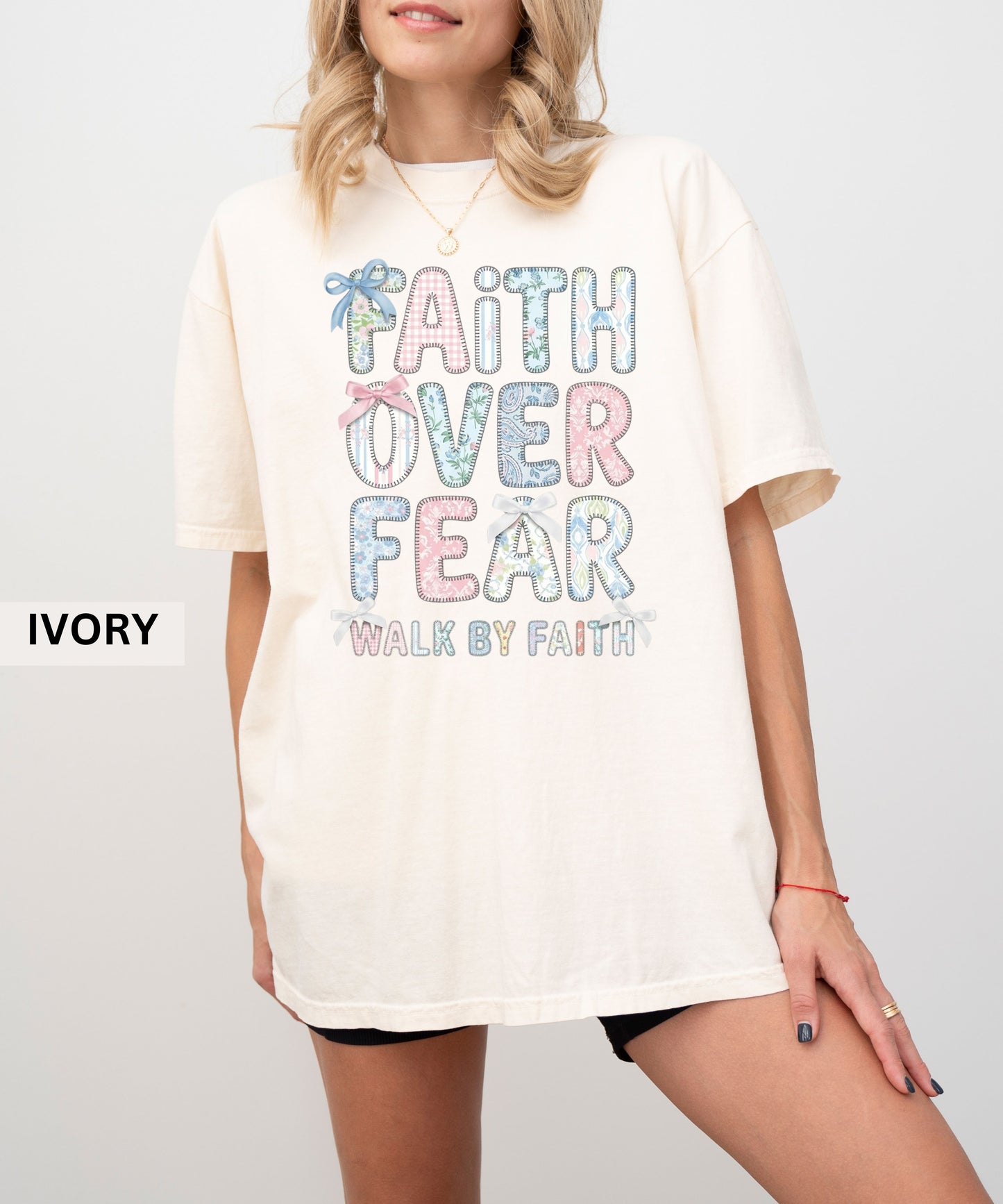 White t-shirt with 'Faith Over Fear' text worn by a person on a white background