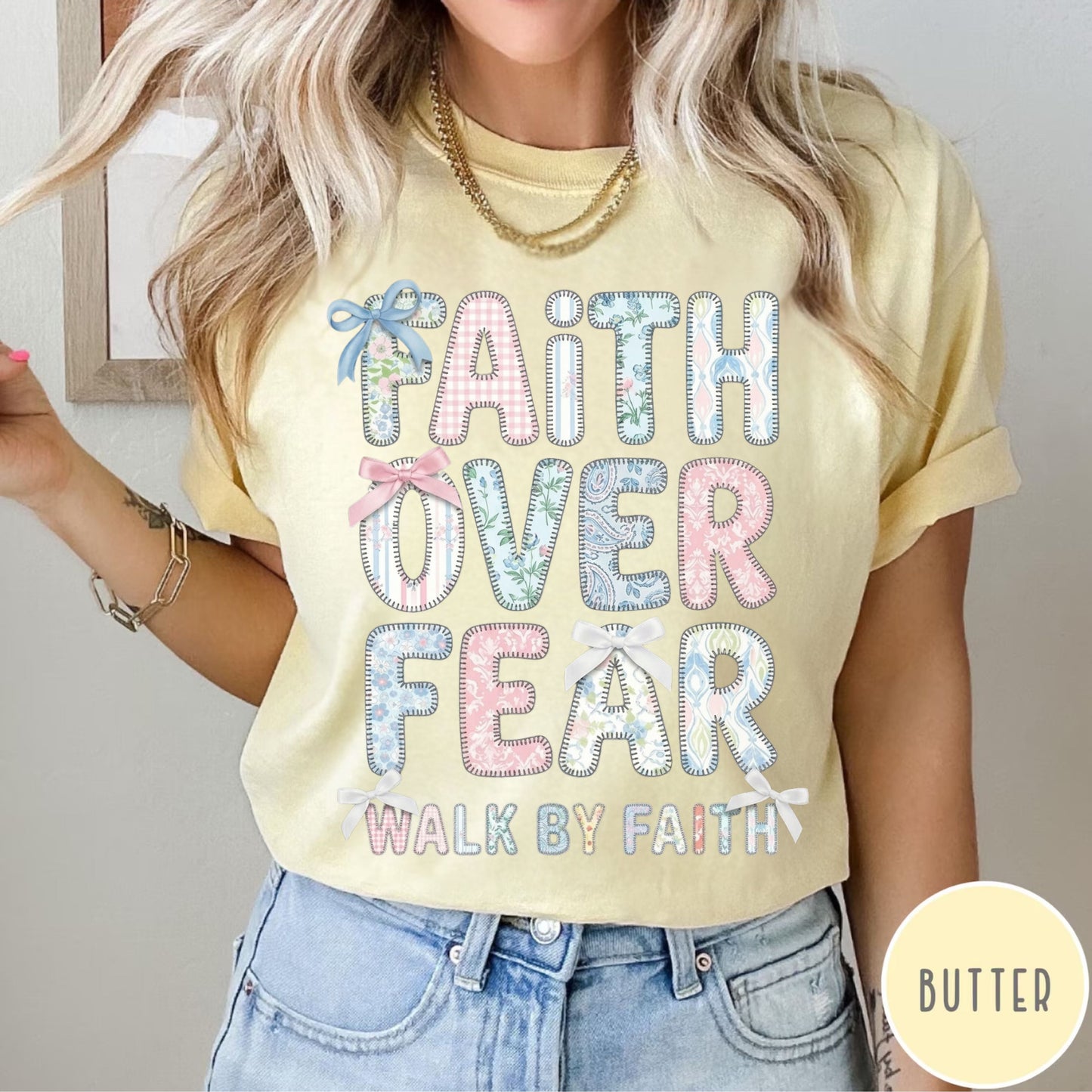Person wearing a butter t-shirt with 'Faith Over Fear' text, standing against a neutral background.