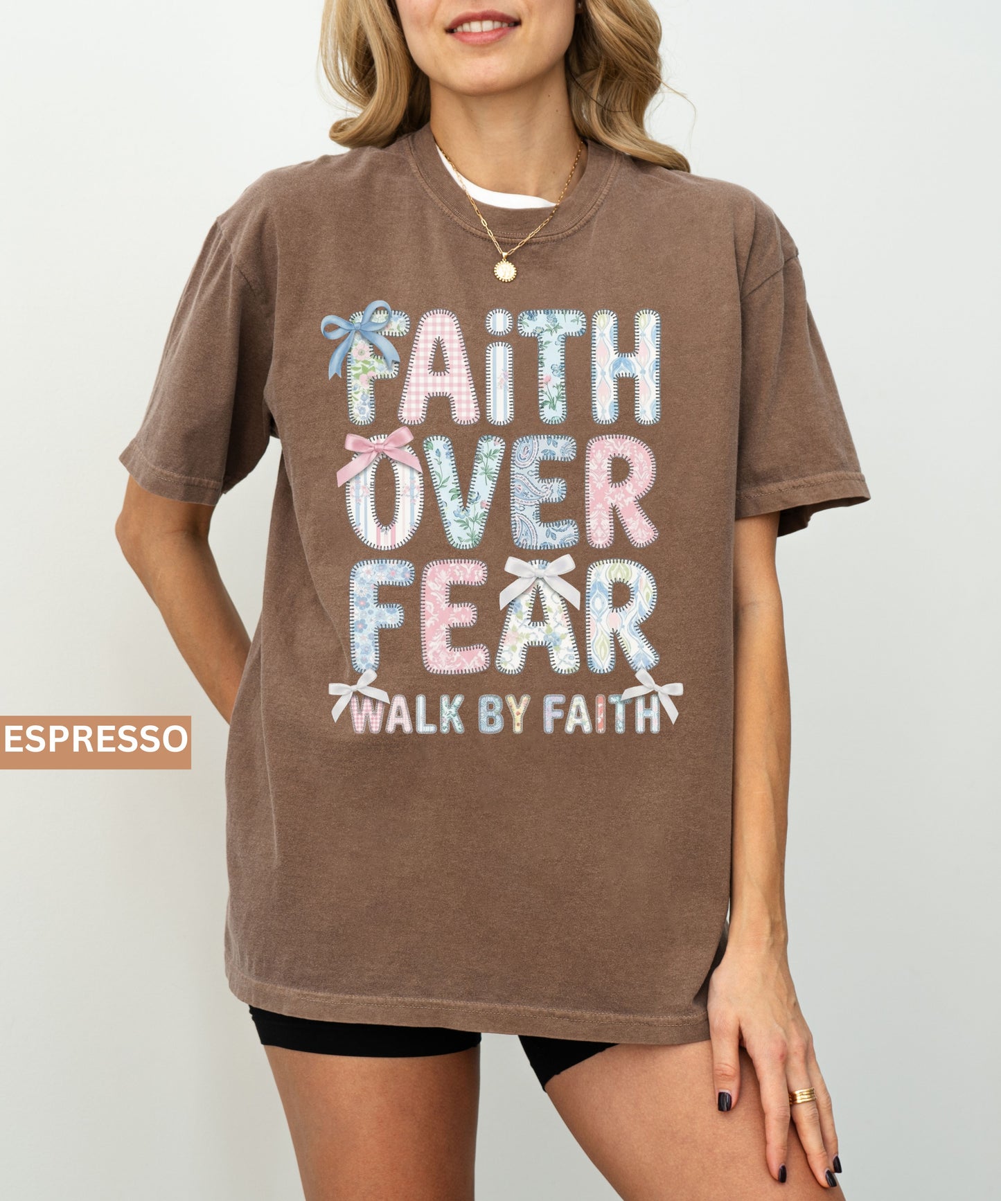 Person wearing an espresso t-shirt with 'Faith Over Fear' text design on a plain background