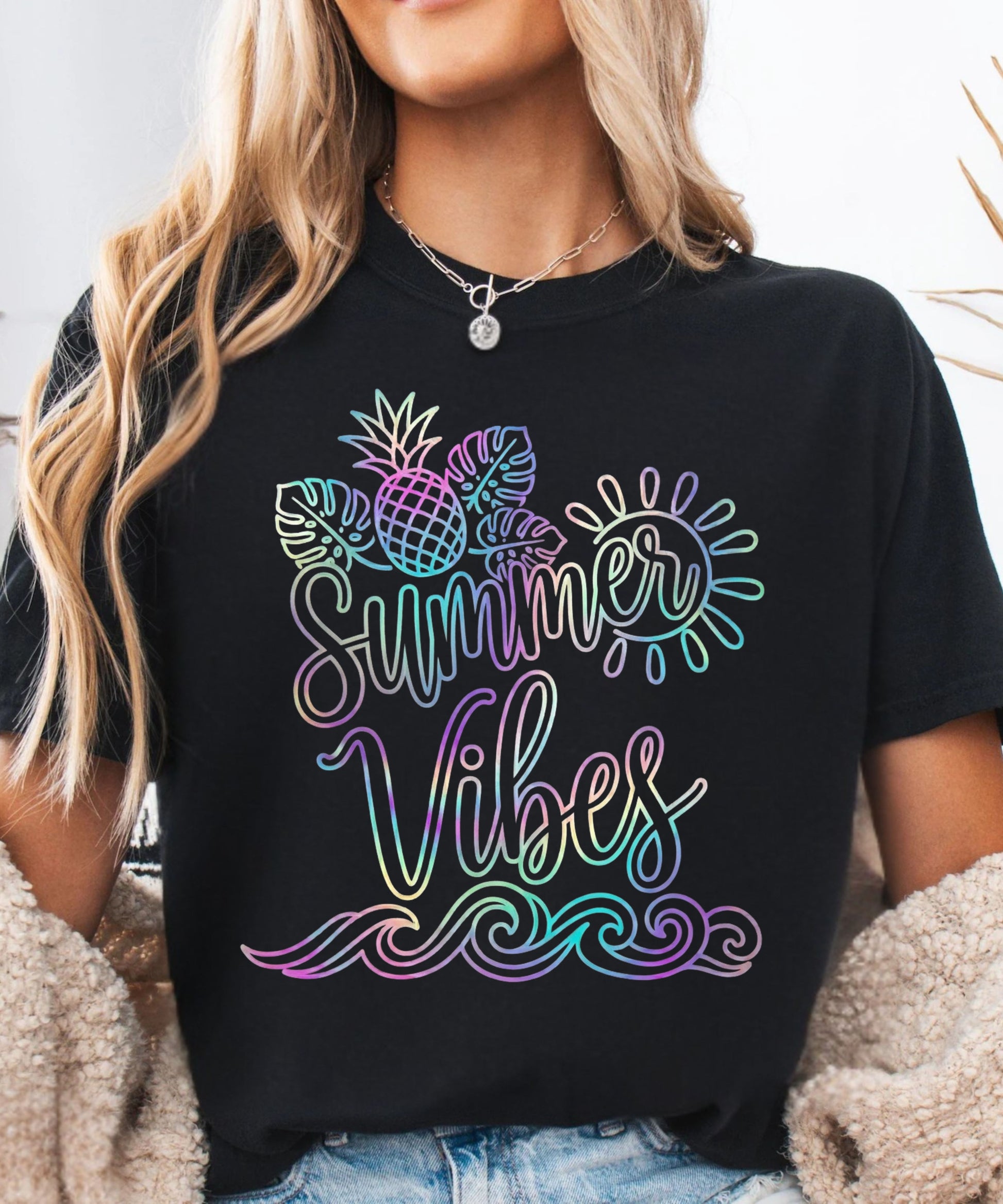 Person wearing a black t-shirt with 'Summer Vibes' colorful design.