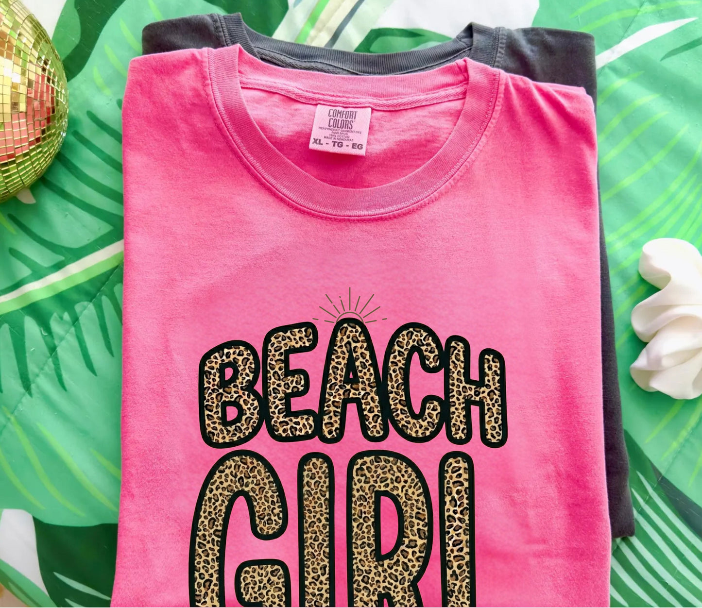 crunchberry color t-shirt with 'Beach Girl' text on a green leafy background