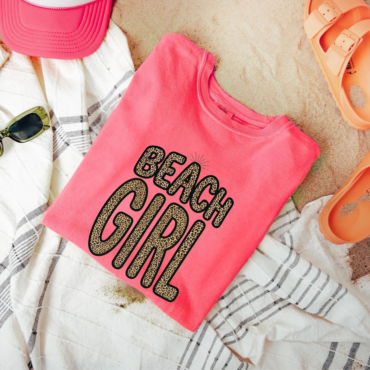 watermelon t-shirt with 'Beach Girl' text on sand with beach accessories.