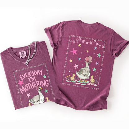 Two berry t-shirts with front and back graphic designs of a mother goose her ducklings with phrase "everyday im mothering" and text on a white background