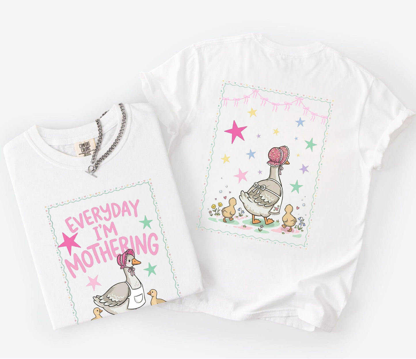 Two white t-shirts with front and back graphic designs of a mother goose her ducklings with phrase "everyday im mothering" and text on a white background