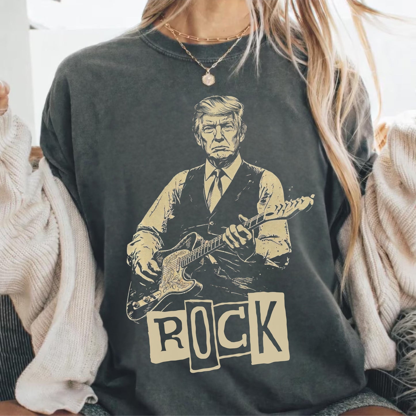 Person wearing a pepper t-shirt with a graphic of president trump playing guitar and the word 'ROCK'.