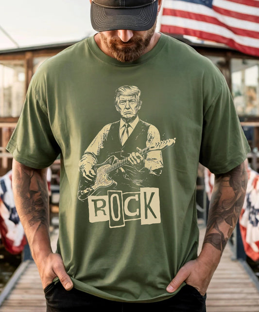 Person wearing a moss t-shirt with a graphic of president trump playing guitar and the word 'ROCK'.