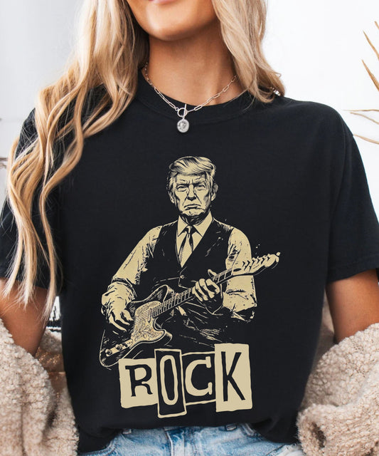 Person wearing a blackr t-shirt with a graphic of president trump playing guitar and the word 'ROCK'.