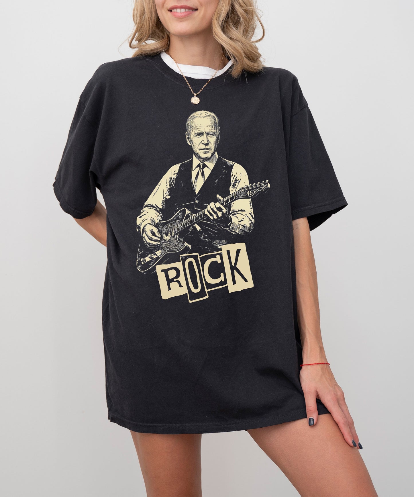 Person wearing a black t-shirt with a graphic of a president Biden playing guitar and the word 'ROCK'.


