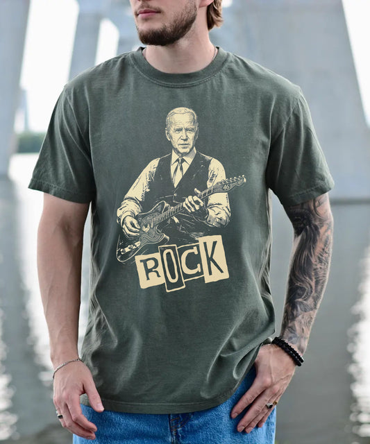 Person wearing a moss t-shirt with a graphic of a president Biden playing guitar and the word 'ROCK'.