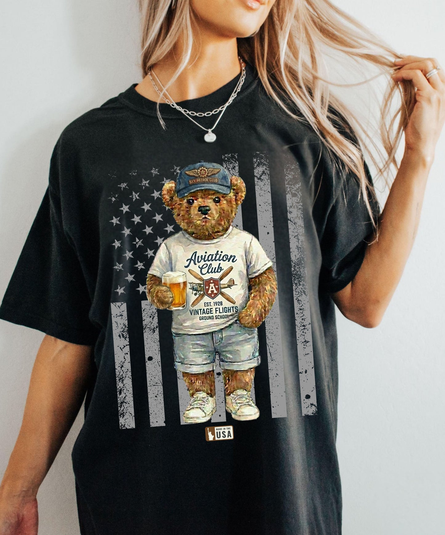 Person wearing a black t-shirt with a bear graphic and American flag design.