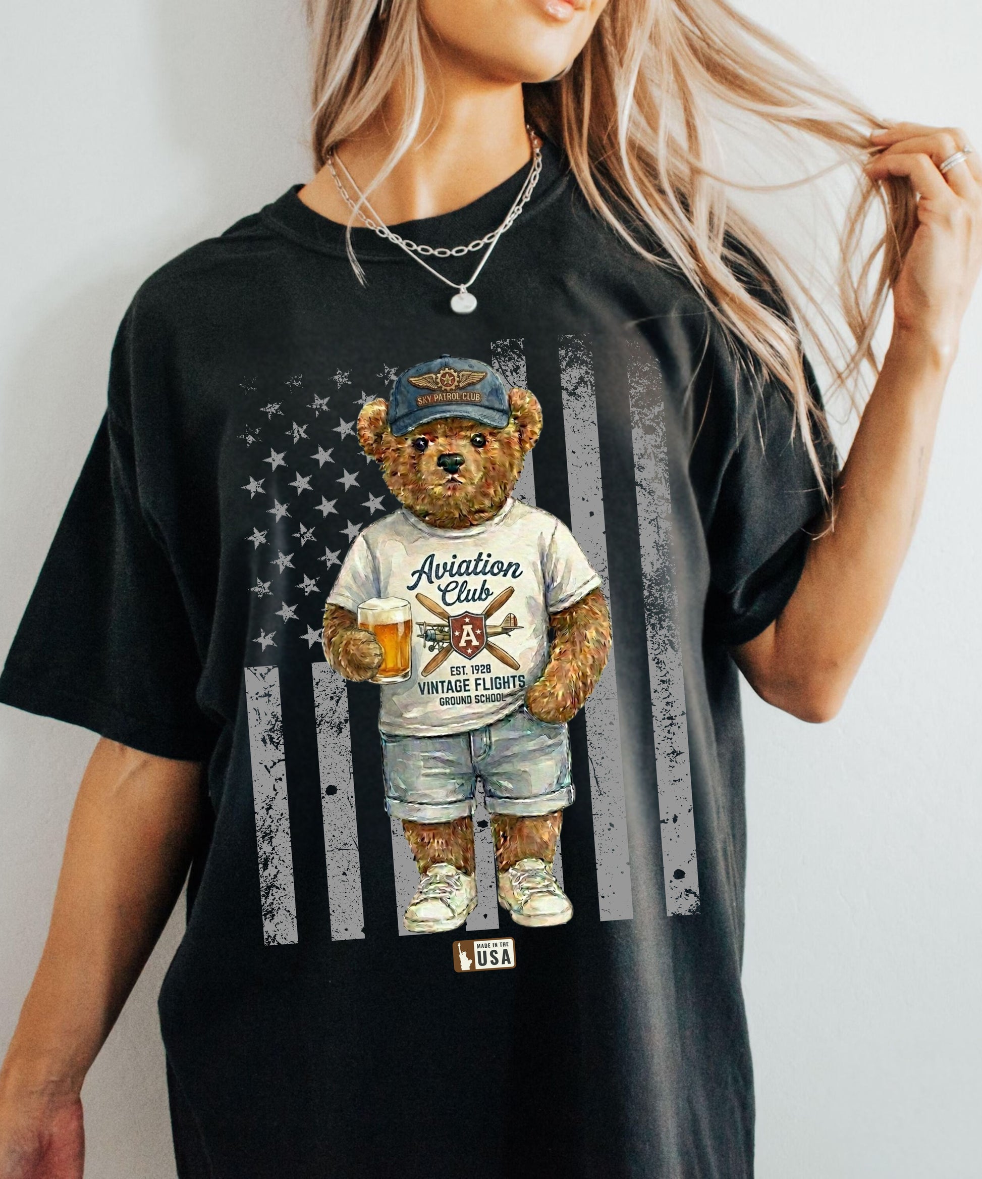 Person wearing a black t-shirt with a bear graphic and American flag design.