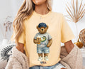 Person wearing a banana t-shirt with a bear graphic holding a beer, sitting in a cozy room.