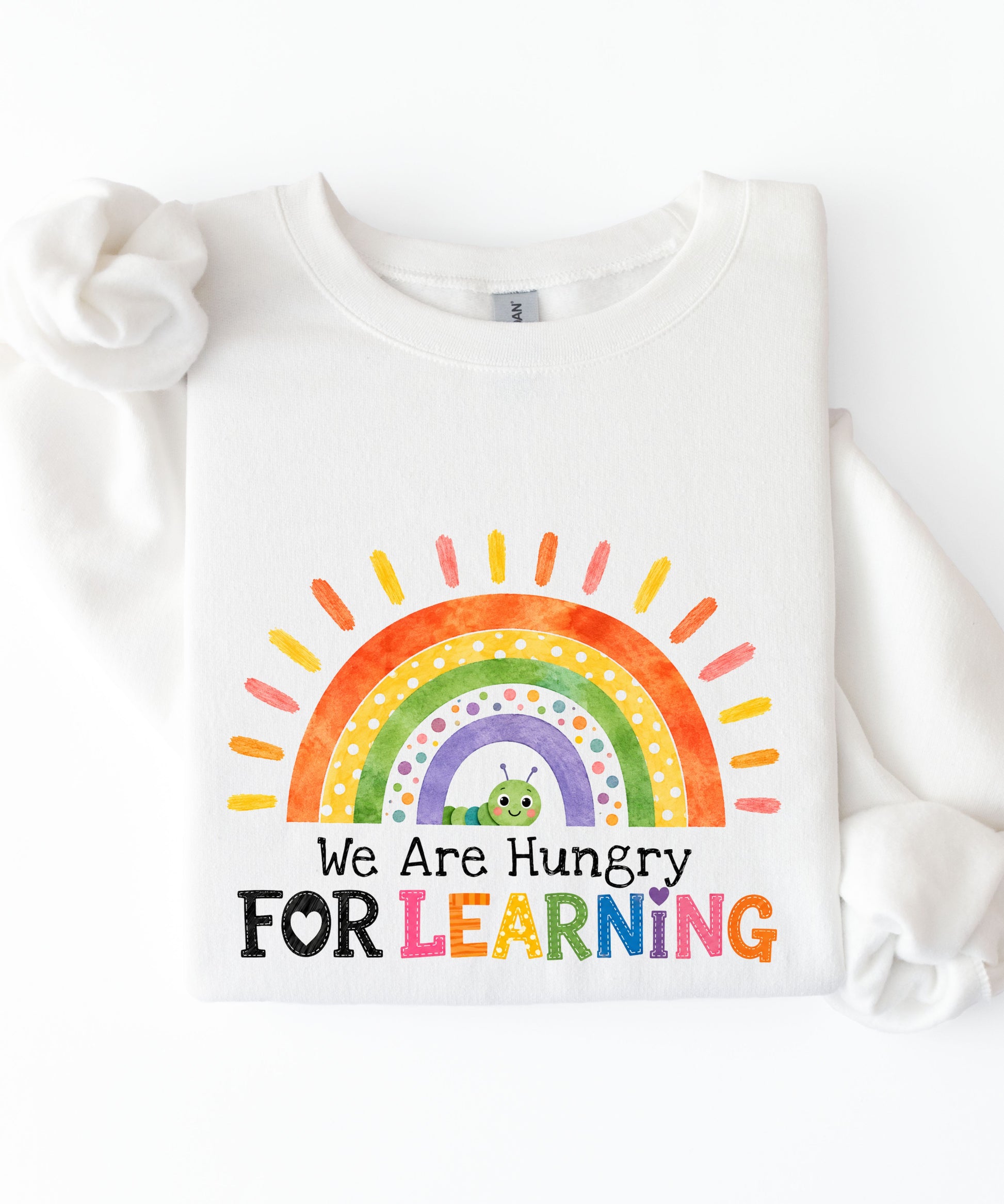 a white sweatshirt with a rainbow and text that says we are hungry for learning design.