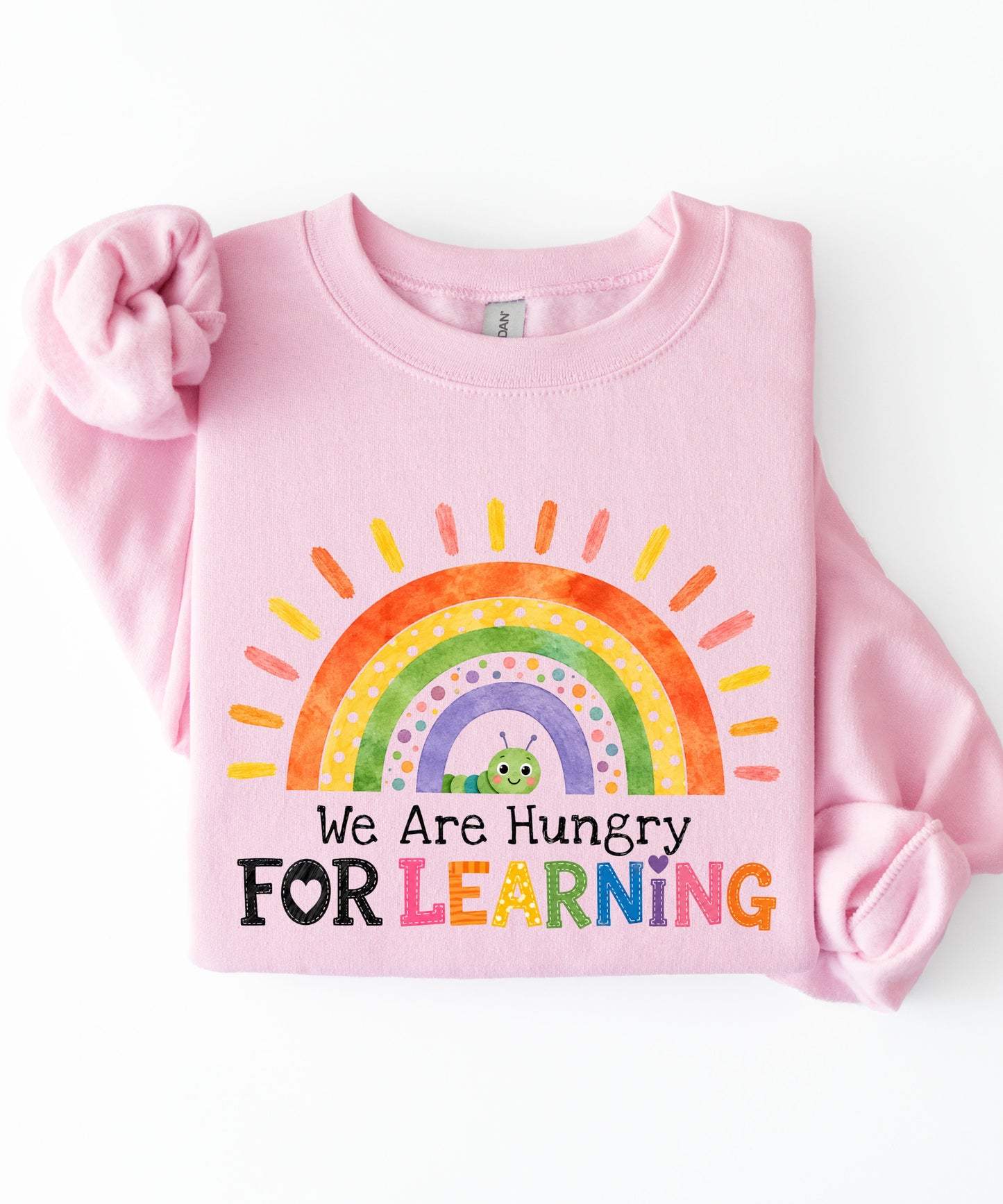 a light pink sweatshirt with a rainbow and text that says we are hungry for learning design.
