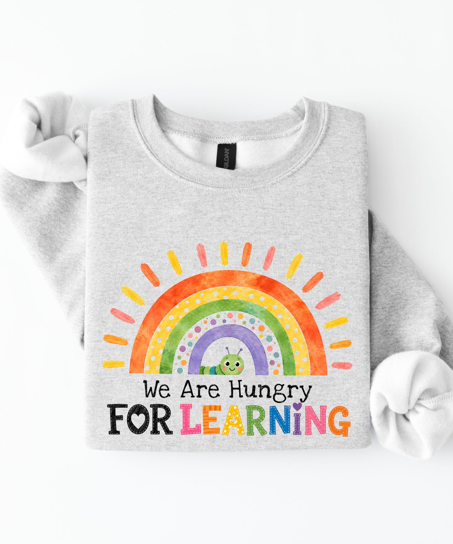 an ash sweatshirt with a rainbow and text that says we are hungry for learning design.