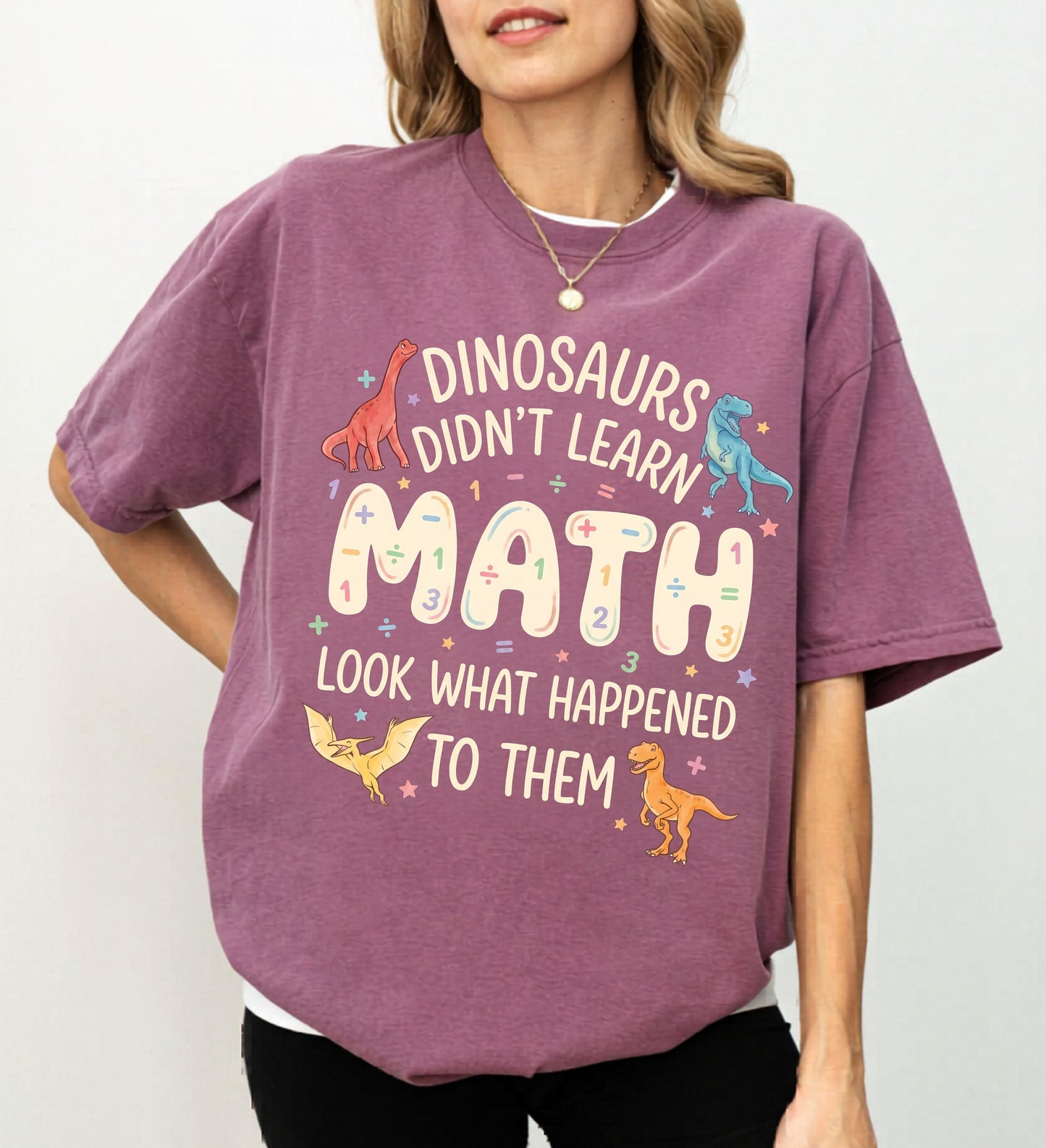 Person wearing a berry t-shirt with dinosaur-themed text on a plain background