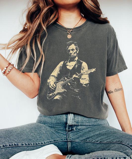 pepper t-shirt with a graphic of a president lincoln  playing guitar on a white background