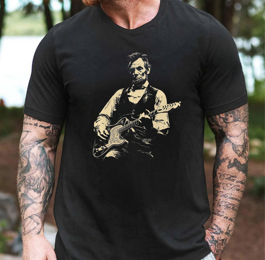 Person wearing a black t-shirt with a graphic of a historical figure playing guitar outdoors.