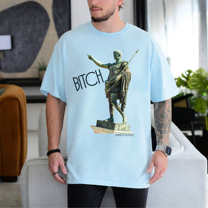 person wearing a chambray blue  t-shirt with a graphic of a statue pointing and the word 'Bitch' on a white background