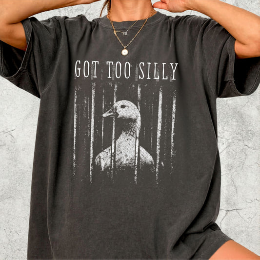 Person wearing a pepper t-shirt with a graphic of a goose and text 'GOT TOO SILLY' on a light gray background