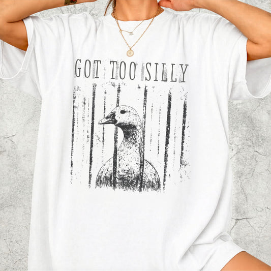 Person wearing a white t-shirt with a graphic of a goose and text 'GOT TOO SILLY' on a light gray background