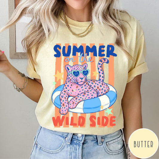 Person wearing a butter colored  t-shirt with a colorful graphic of a panther and text 'Summer on the Wild Side'.