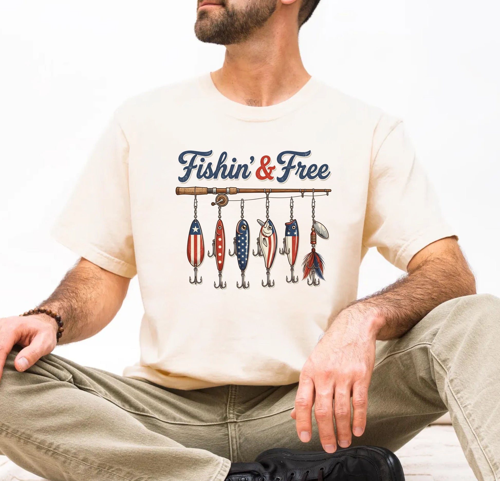 Man wearing an ivory t-shirt with 'Fishin' & Free' graphic design.