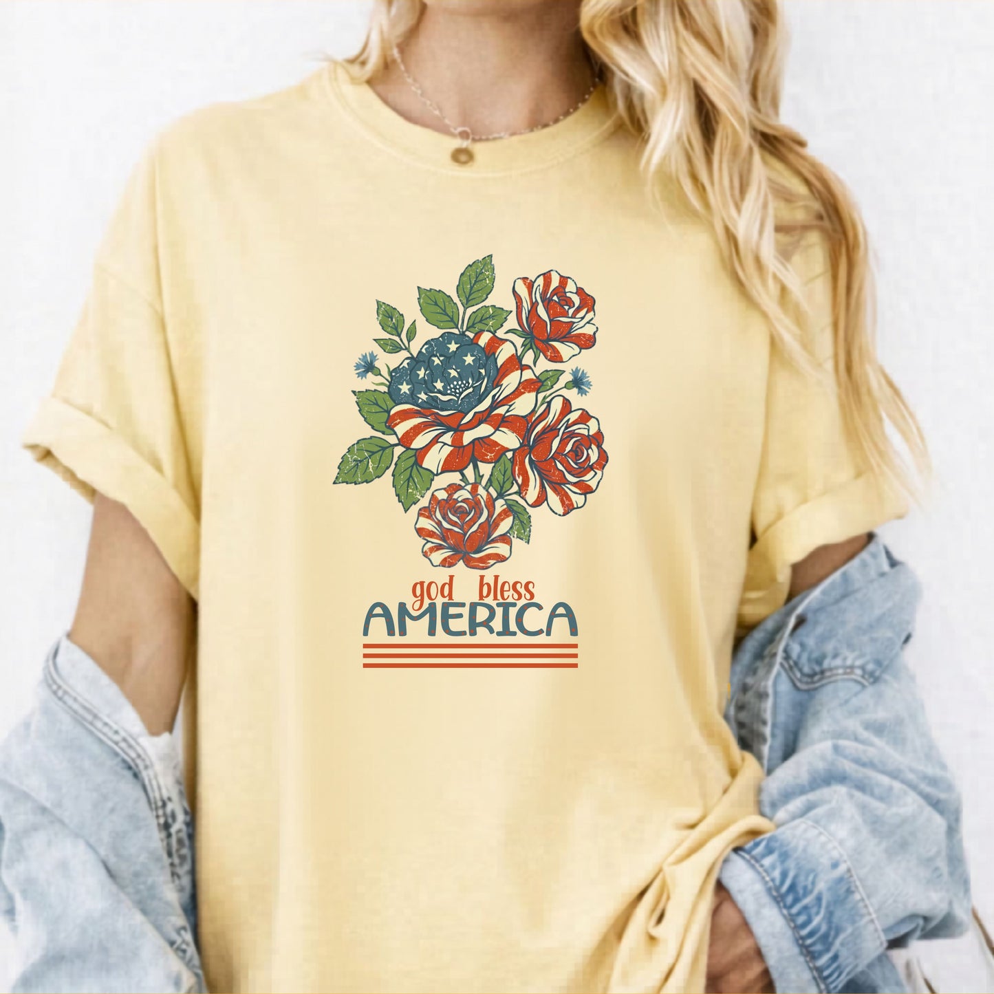 Butter garment-dyed t-shirt with patriotic floral God Bless America graphic on chest