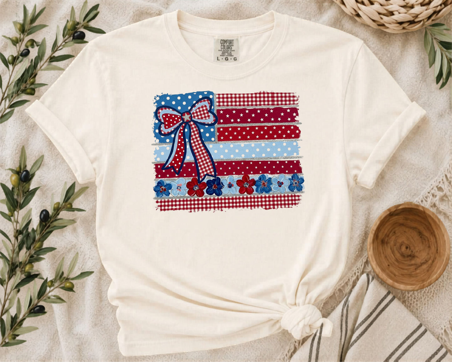 Ivory garment-dyed t-shirt with Americana patchwork flag bow graphic in red, white and blue