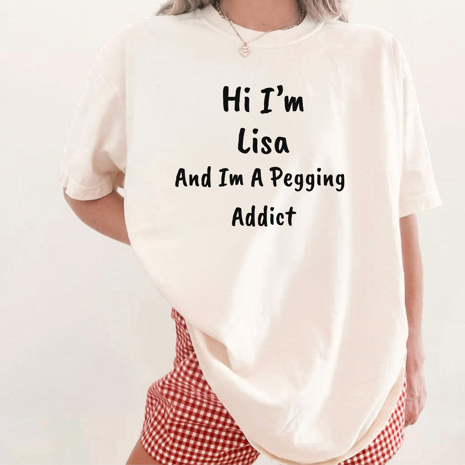 Ivory garment-dyed heavyweight t-shirt with personalized 'Hi I'm [Name] And I'm A Pegging Addict' graphic in handwritten-style font, centered on chest