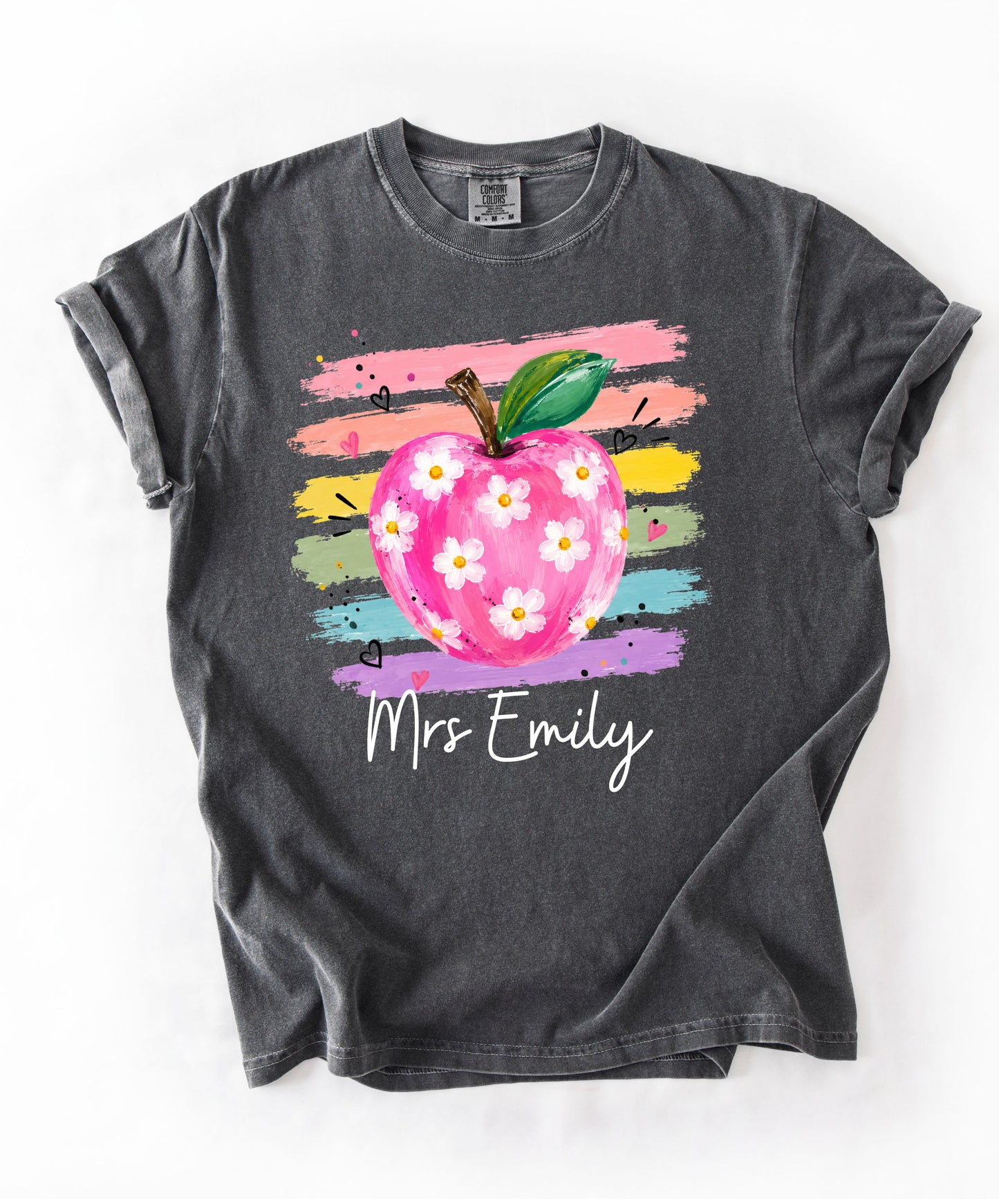 Personalized teacher t-shirt in Pepper with floral apple graphic and colorful brushstroke stripes, custom name in script — garment-dyed cotton tee