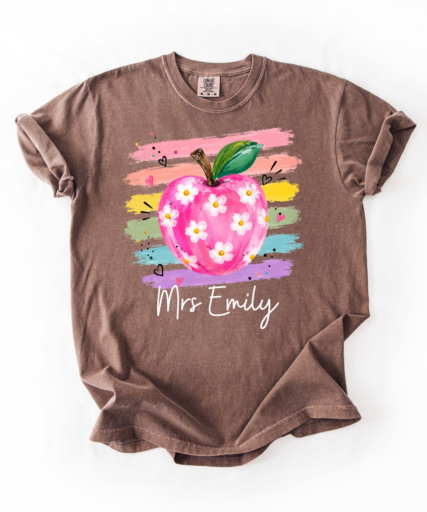 Personalized teacher t-shirt in Espresso with floral apple graphic and colorful brushstroke stripes, custom name in script — garment-dyed cotton tee