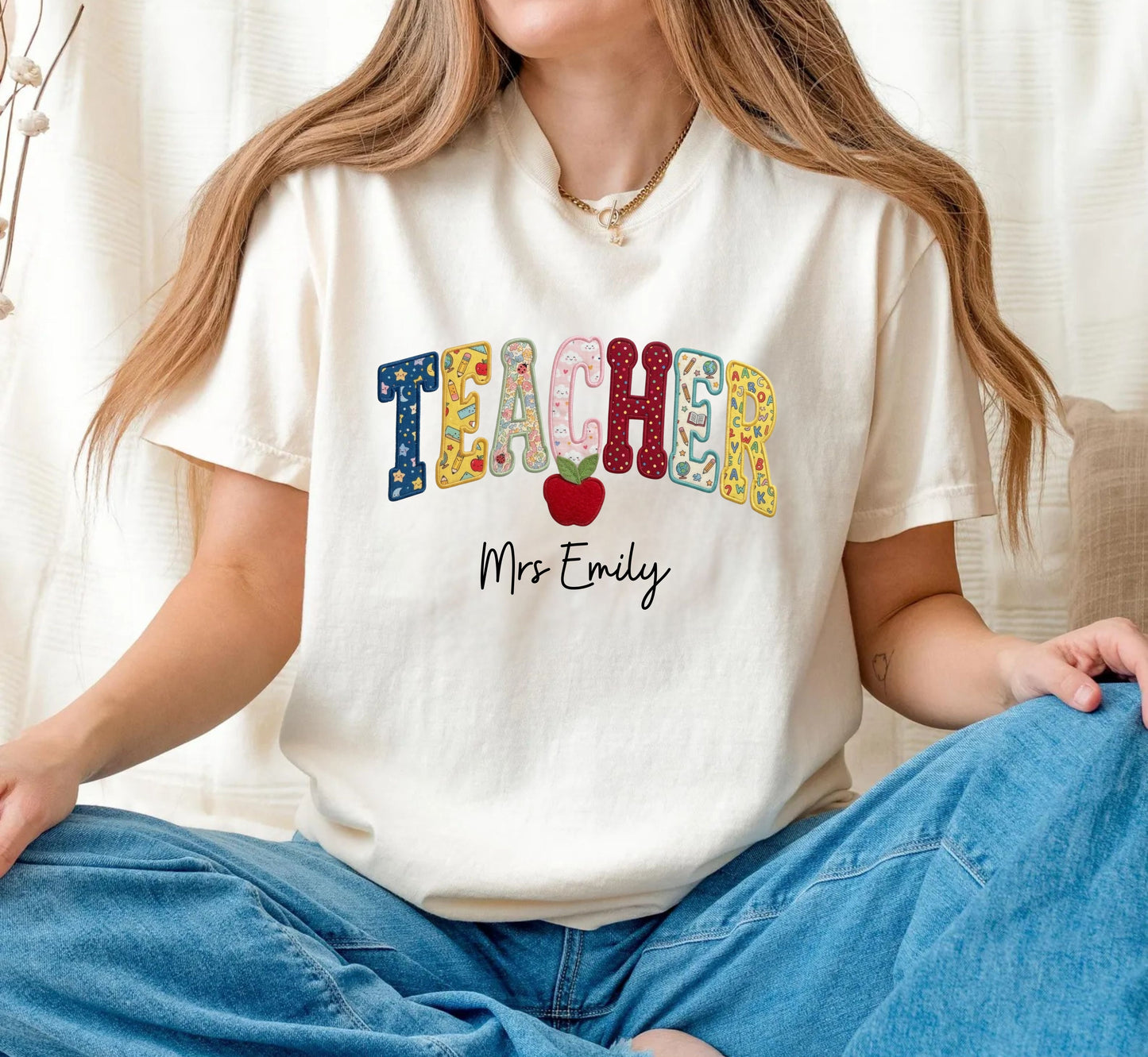 Personalized teacher shirt in Ivory with faux patchwork TEACHER lettering, red apple graphic, and custom name — garment-dyed heavyweight tee