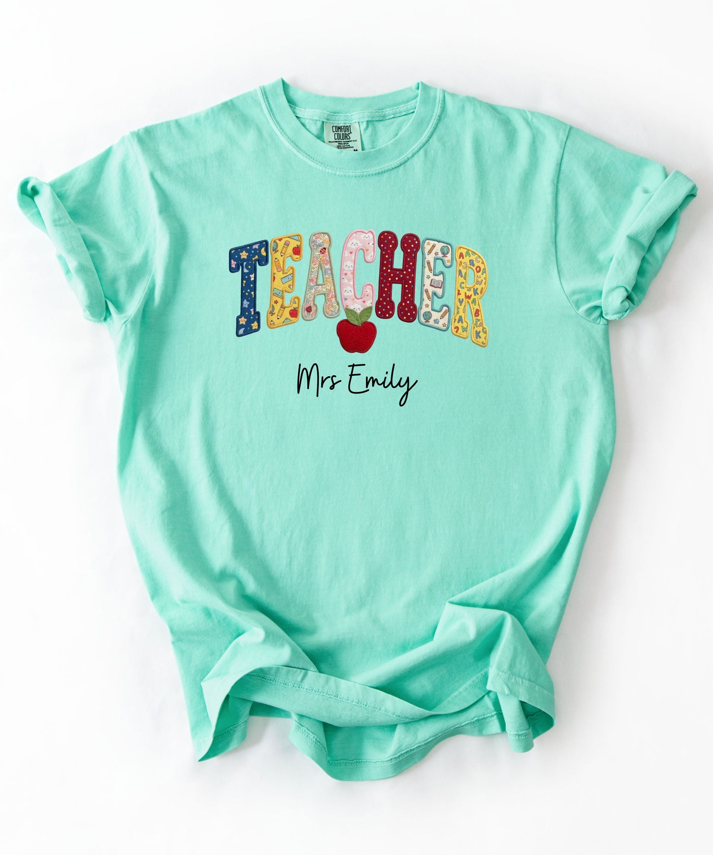 Personalized teacher shirt in Island Reef with faux patchwork TEACHER lettering, red apple graphic, and custom name — garment-dyed heavyweight tee