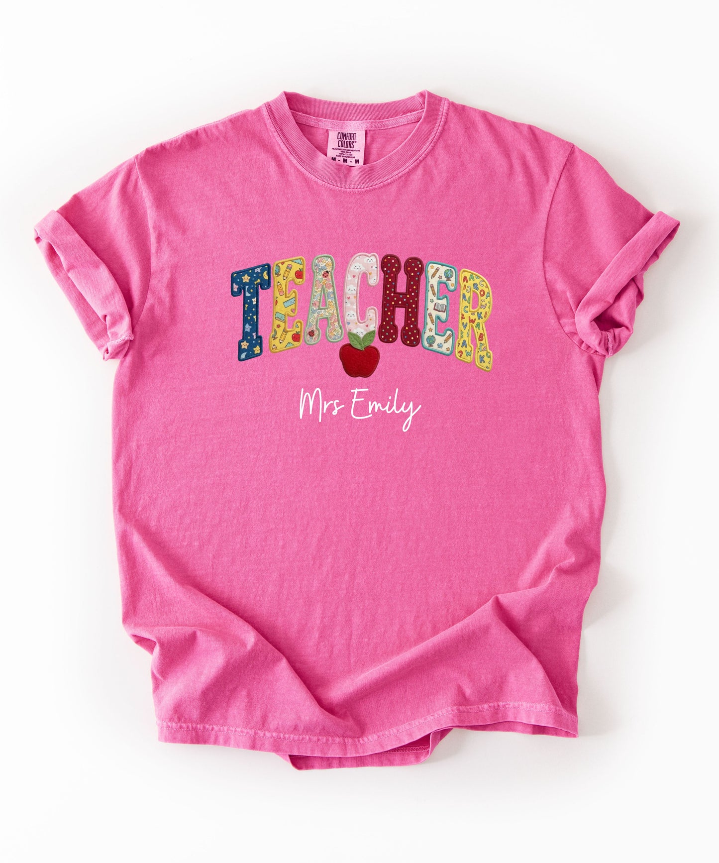 Personalized teacher shirt in Crunchberry with faux patchwork TEACHER lettering, red apple graphic, and custom name — garment-dyed heavyweight tee