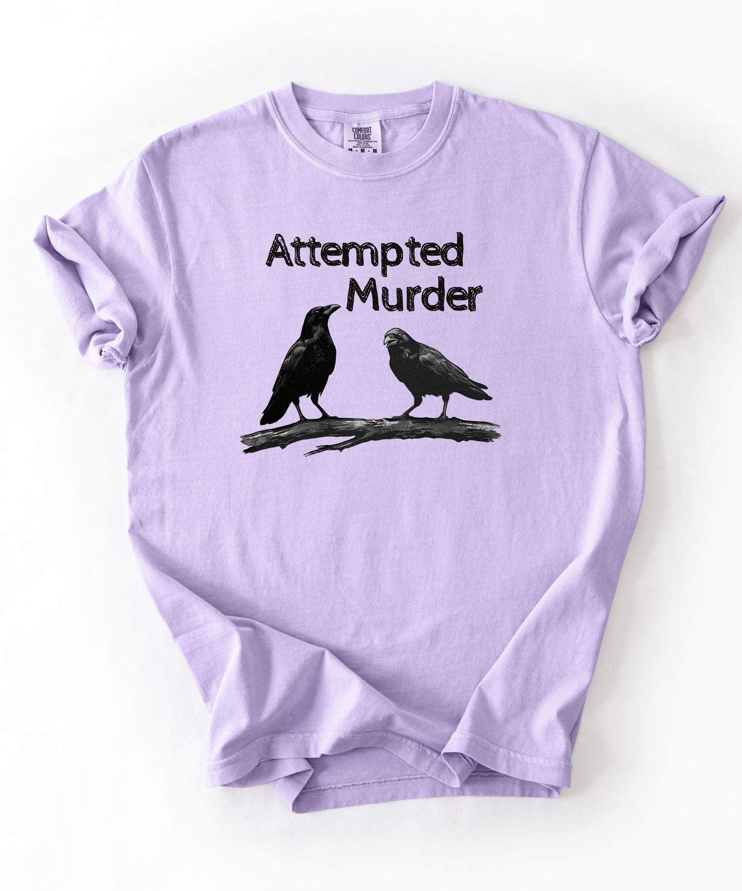 Orchid garment-dyed unisex crow graphic tee — Attempted Murder dark humor bird pun shirt