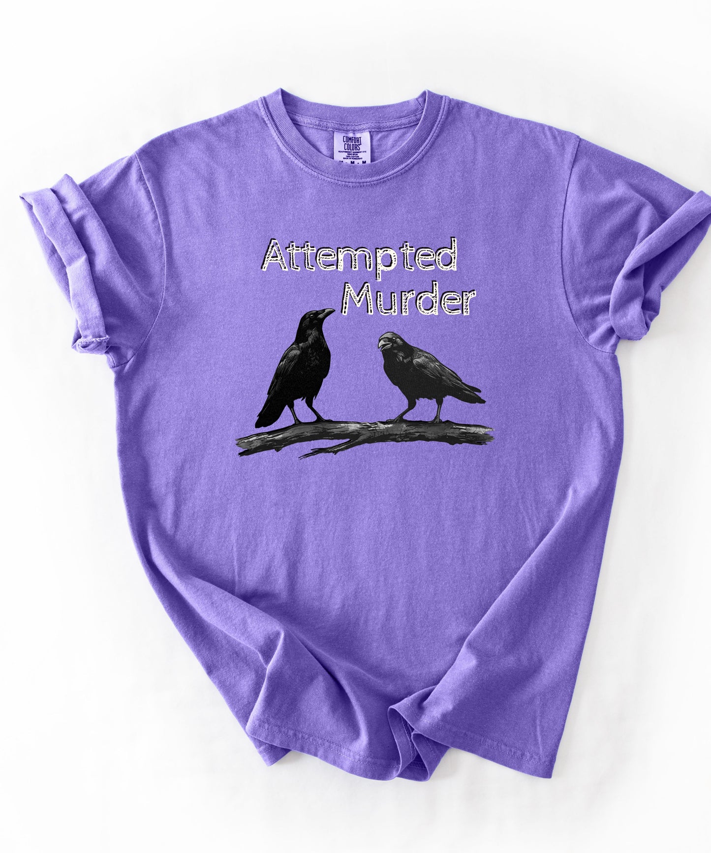 Violet garment-dyed unisex crow graphic tee — Attempted Murder dark humor bird pun shirt