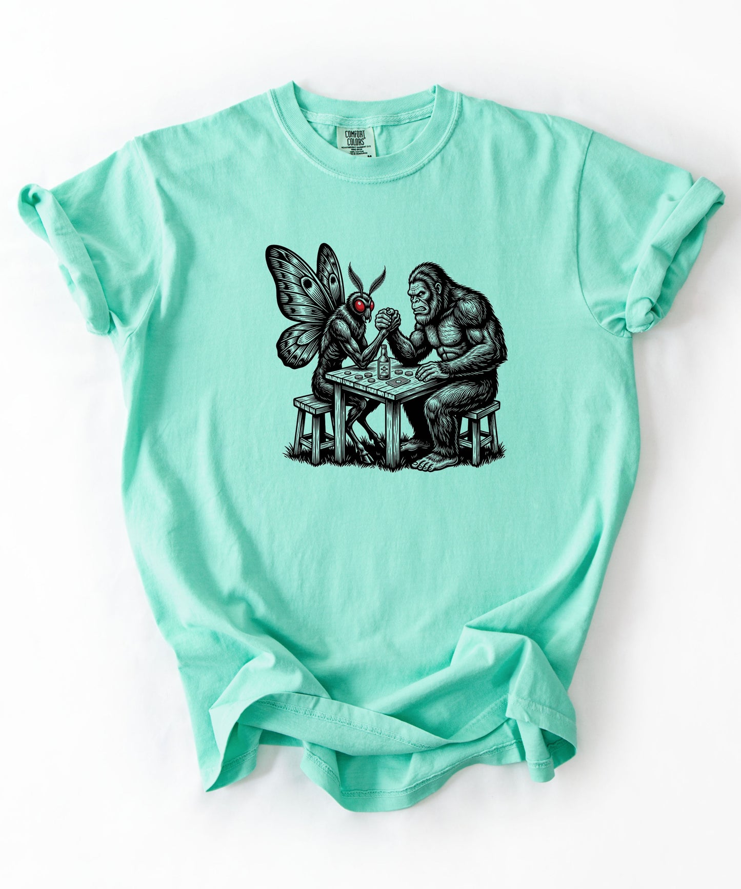 Island Reef garment-dyed unisex Bigfoot vs Mothman arm wrestling graphic tee — funny cryptid shirt